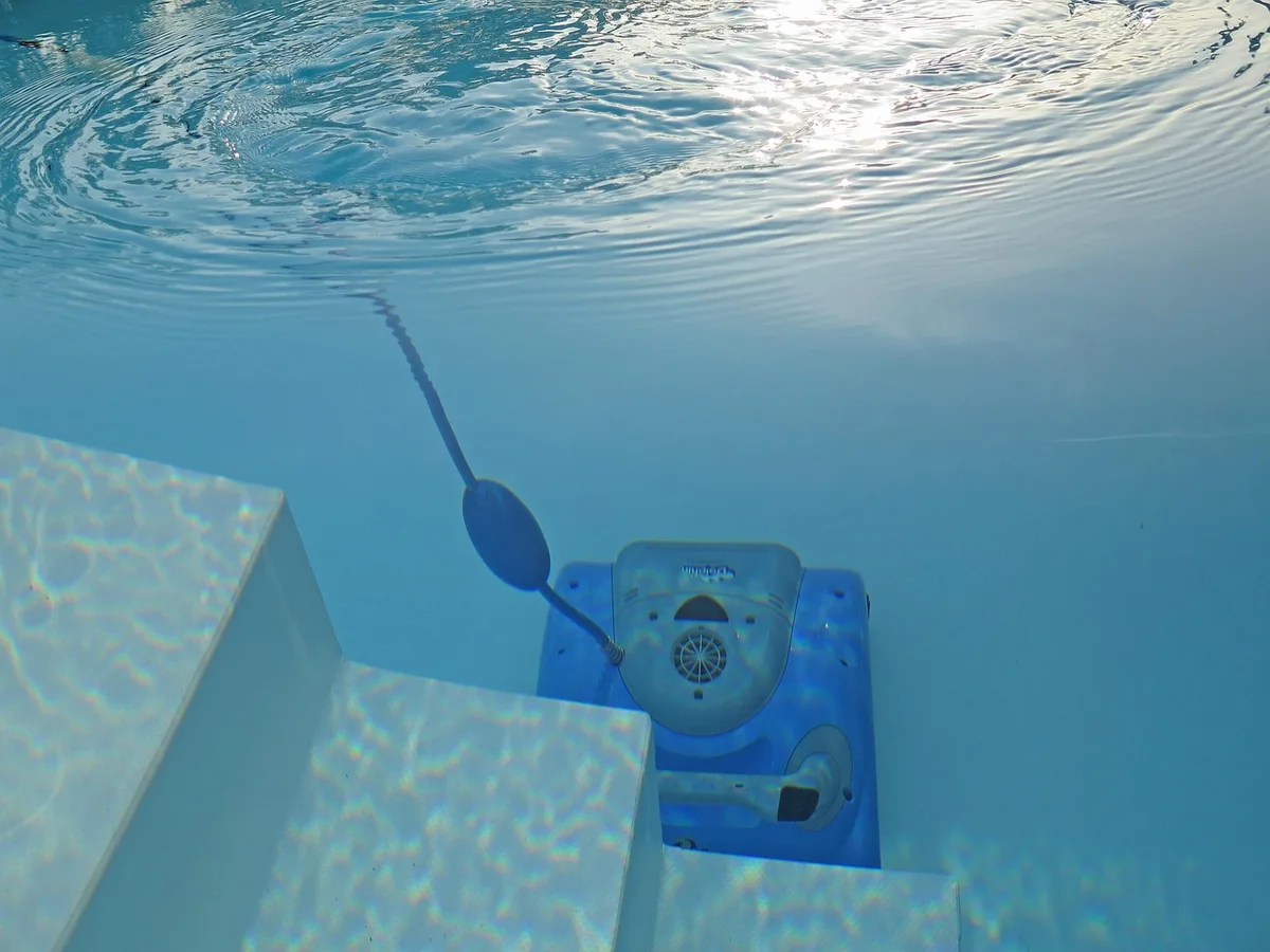 Robot limpiafondos trabajando en el fondo de una piscina